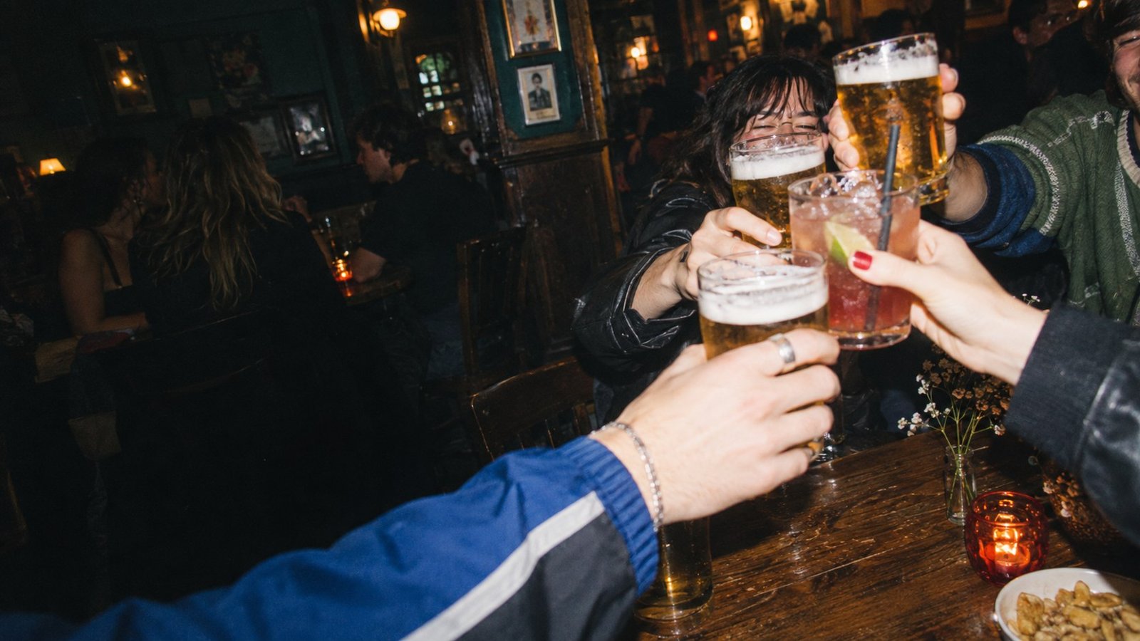 Friends raising drinks together in a Bristol pub